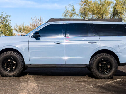 Side profile of a Ford Expedition SUV equipped with a heavy-duty aluminum overlanding roof rack for adventure travel.