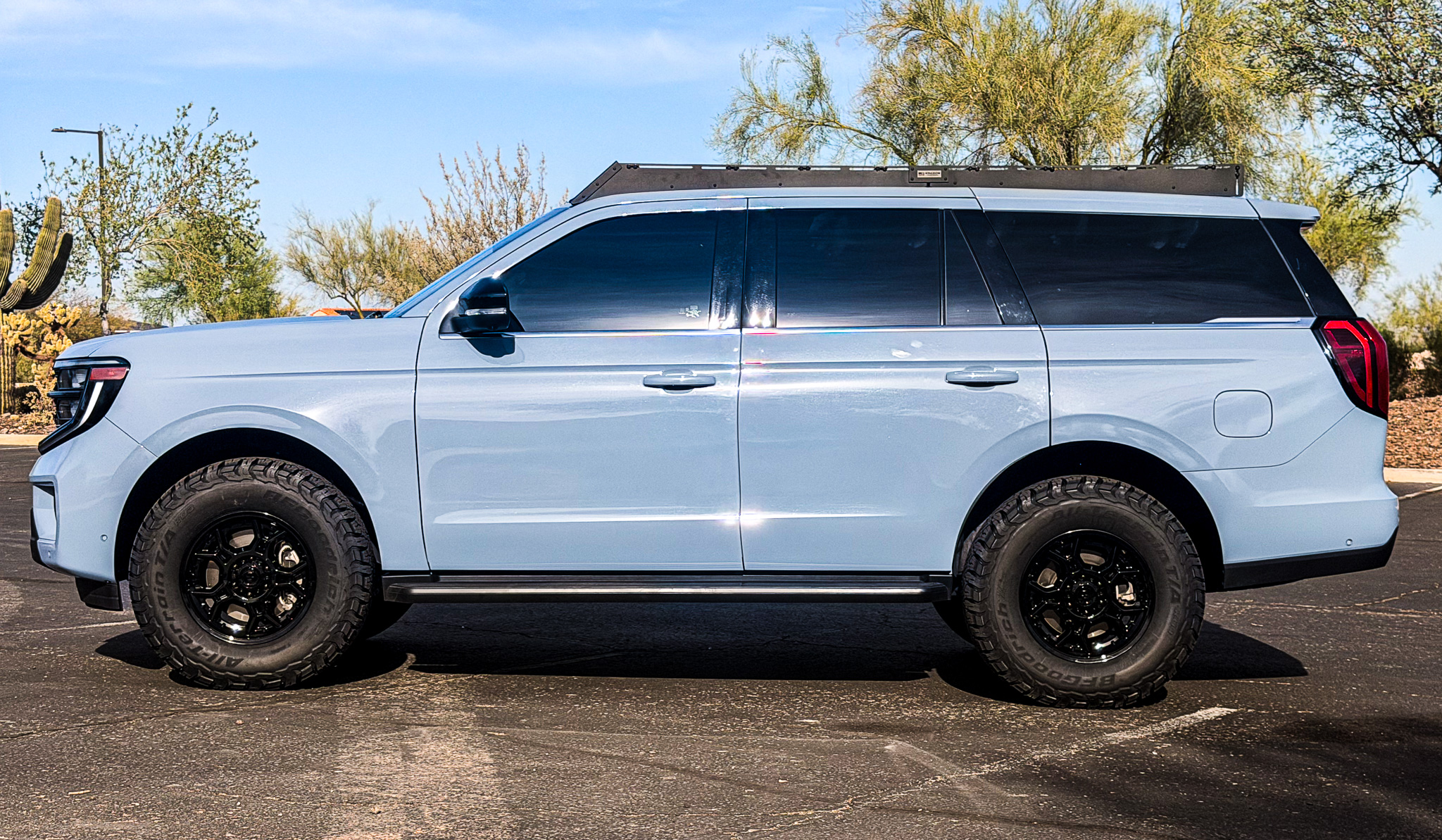 ford-expedition-side-view-aluminum-overlanding-roof-rack.jpg Side profile of a Ford Expedition SUV equipped with a heavy-duty aluminum overlanding roof rack for adventure travel.